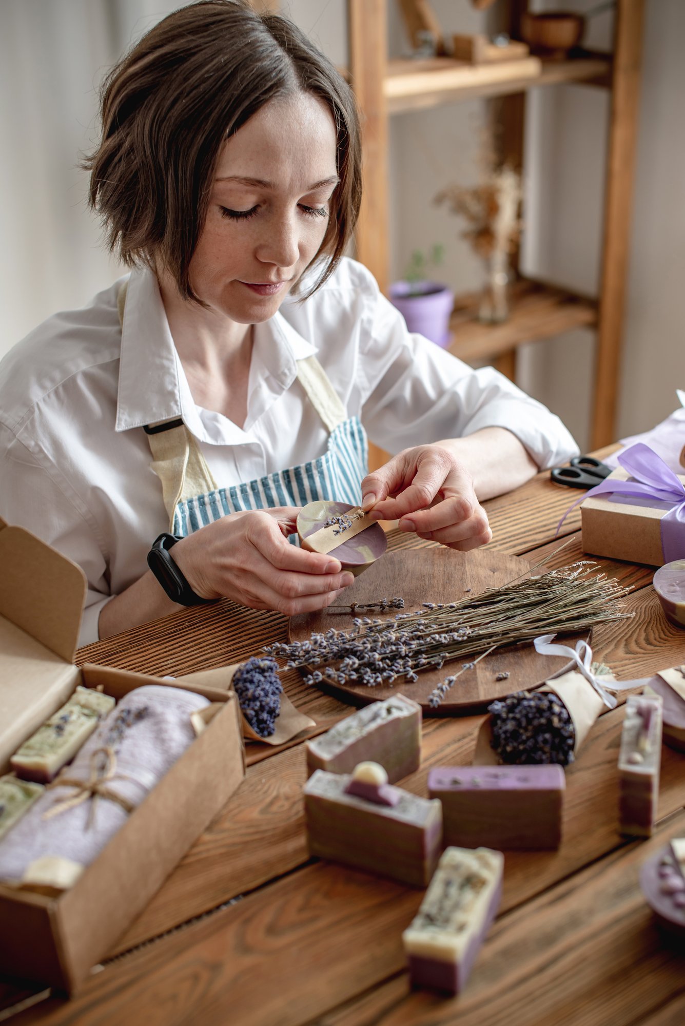 woman-apron-is-packing-natural-lavender-soap-decorating-it-with-lavender-flowers-concept-natural-soap-handmade-gifts woman-apron-is-packing-natural-lavender-soap-decorating-it-with-lavender-flowers-concept-natural-soap-handmade-gifts